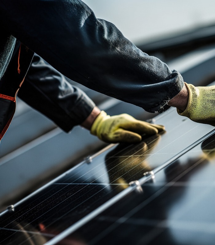 Employee of a solar panel installation company on the roof during the assembly of a photovoltaic system installation